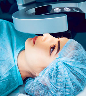 Lady in scrubs under eye machine ready for surgery