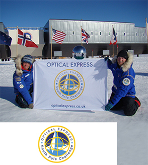 Two men on South Pole holding up Optical Express South Pole Challenge banner
