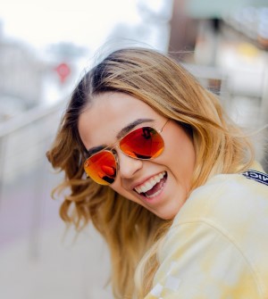 Smiling blond woman wearing orange sunglasses