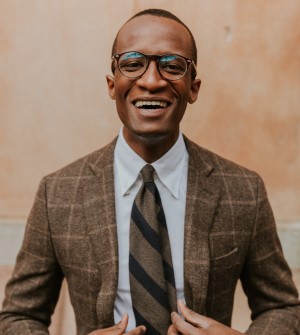 Smiling man with glasses wearing brown suit