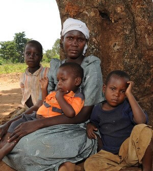 Woman with three children in front of tree in Africa